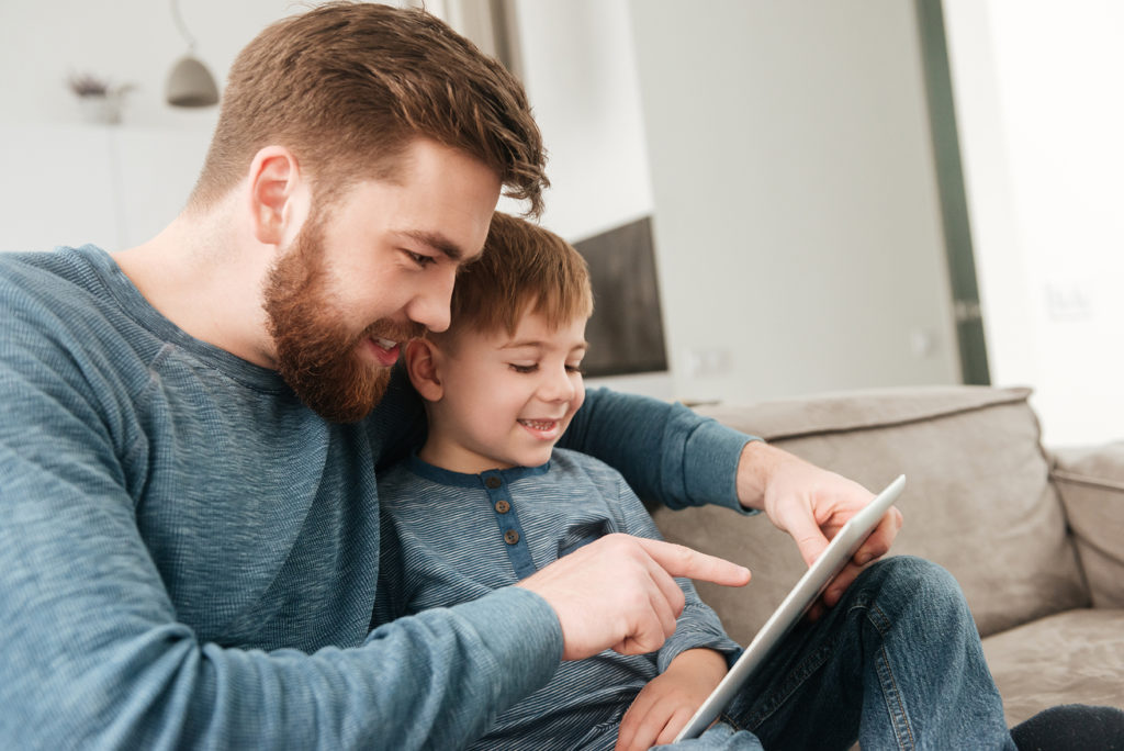 Father and young son watching a tablet